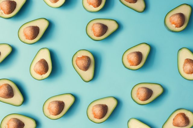 Avocado colorful pattern on a pastel blue background. Summer concept. Flat lay.