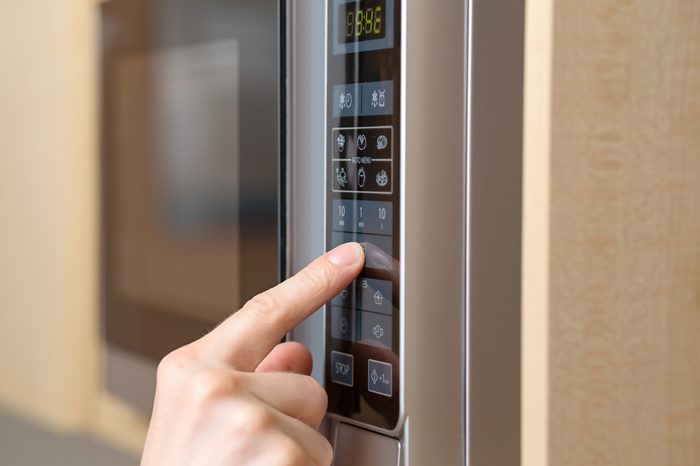 Detail of male hand while using the microwave