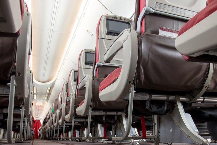 Aisle seats on planes from below view. An empty row of seats in a airplane. Rear side chairs with monitors on the aircraft.