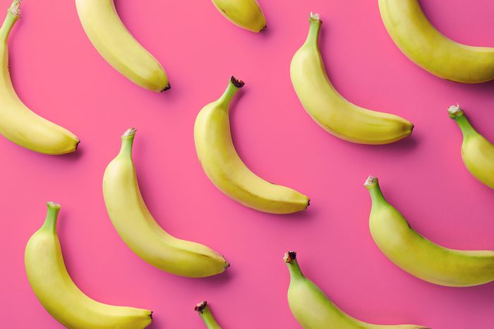 Colorful fruit pattern of fresh yellow bananas on pink background. From top view