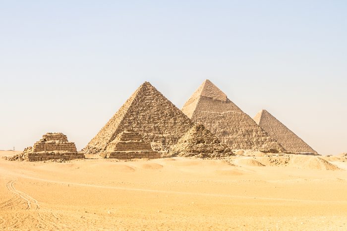 Giza pyramids in Cairo, Egypt. General view of pyramids from the Giza Plateau Three pyramids known as Queens' Pyramids on front side. Next in order from left, the Pyramid of Menkaure, Khafre and Chufu