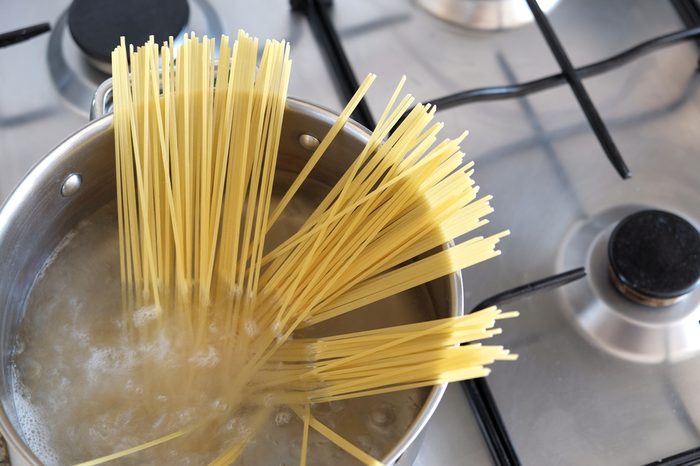 Boiling spaghetti in a silver pot with hot water