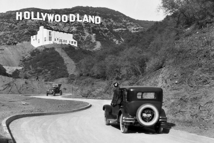 Mandatory Credit: Photo by Underwood Archives/UIG/Shutterstock (3838241a) Hollywood, Los Angeles: c. 1924 A sign advertises the opening of the Hollywoodland housing development in the hills on Mulholland Drive overlooking Los Angeles. The white building below the sign is the Kanst Art Gallery, which opened on April 1, 1924 VARIOUS