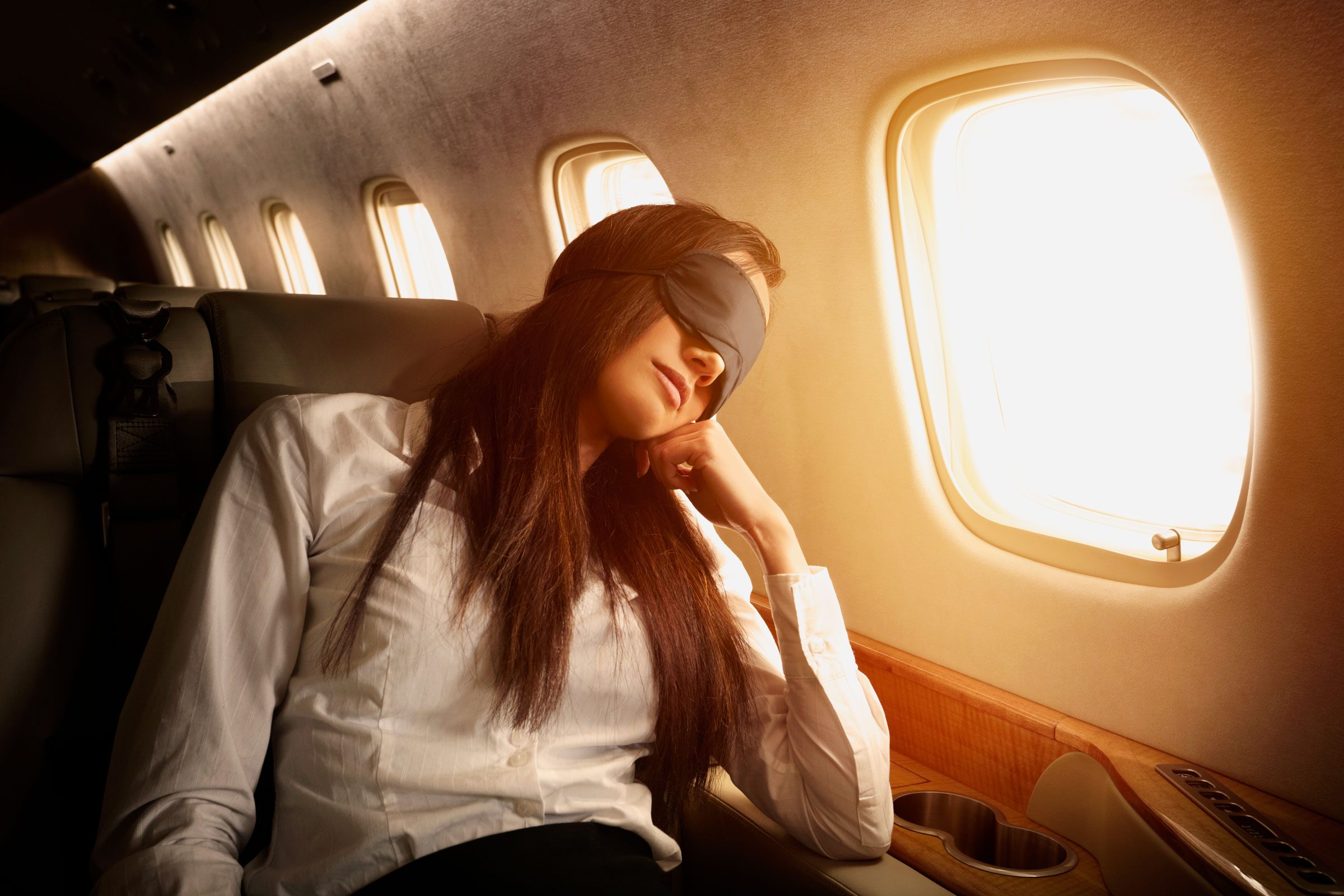 Pacific Islander businesswoman sleeping on private jet