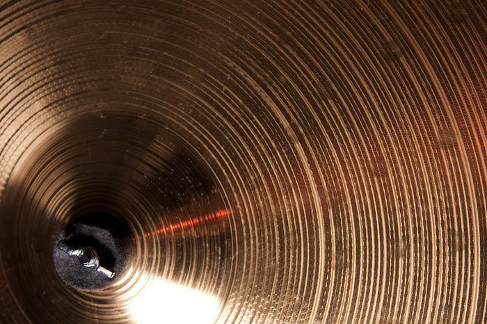 A bronze brass cymbal isolated close up in the horizontal format.