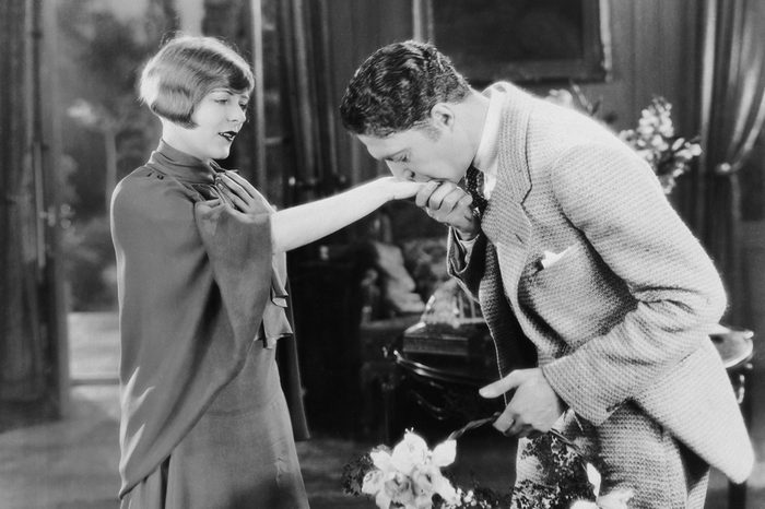 Man with flowers kissing womans hand