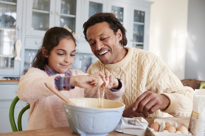 Father And Daughter Baking Cookies At Home Together