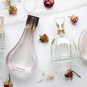 bottle of woman perfume on white background with roses. gift.