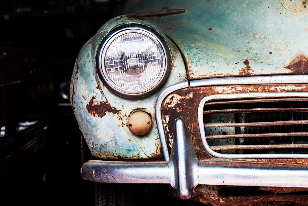 Detail of the front headlight of an old car in garage