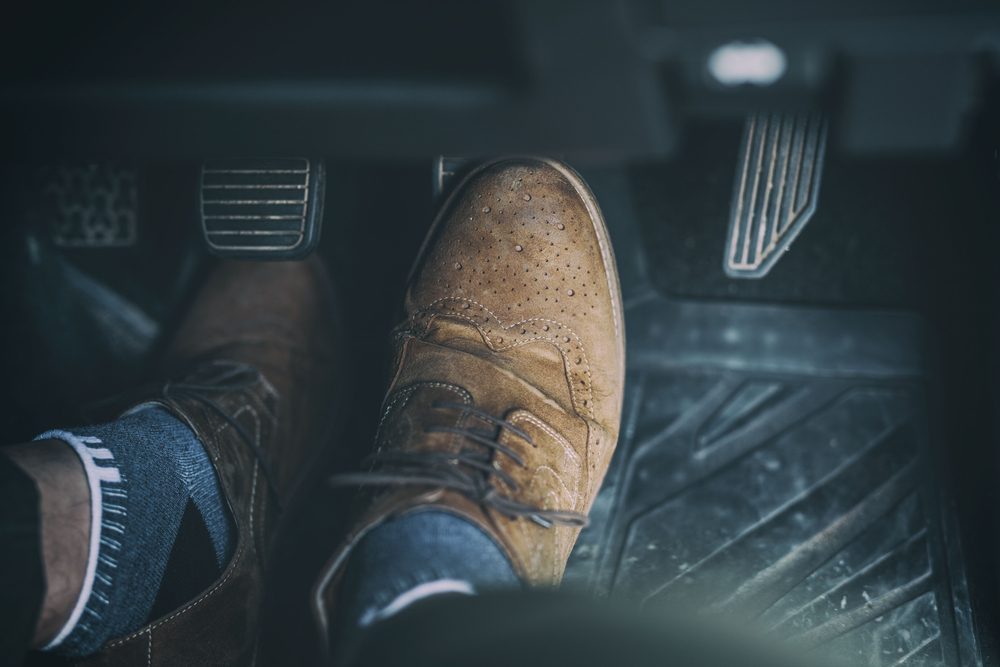 Man foot press the break pedal of a car.