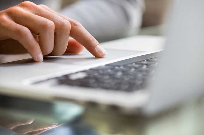 Woman using laptop indoor.close-up hand