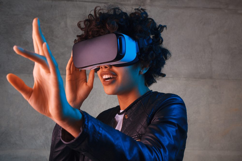 Amazed young woman touching the air during the VR experience. Horizontal studio shot.