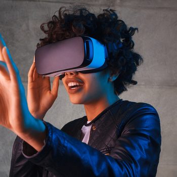 Amazed young woman touching the air during the VR experience. Horizontal studio shot.