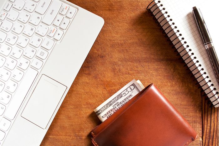 Laptop, notebook and money for business and shopping on a working desk