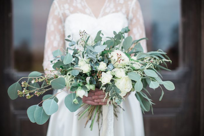 Handed wedding bouquet with roses and eucalyptus greenery.