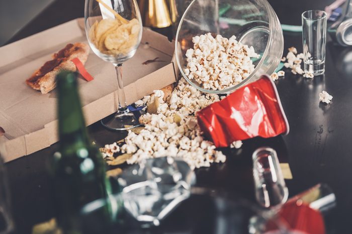 Close-up view of popcorn, glasses and trash on messy table after party