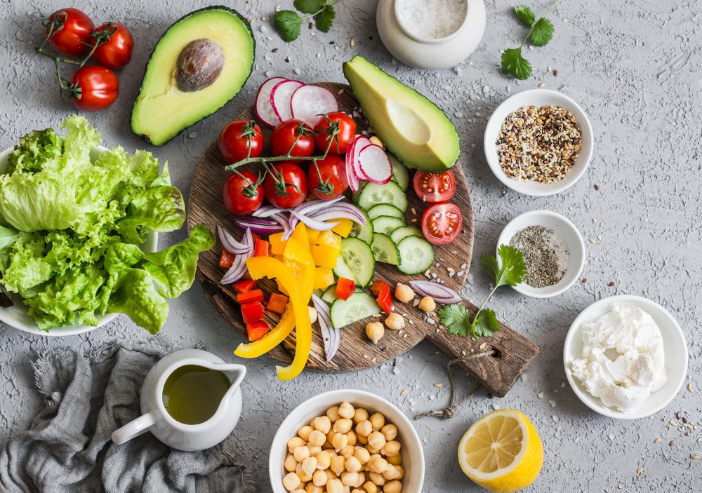 Ingredients for spring vegetable buddha bowl. Delicious healthy food. On a gray background, top view 