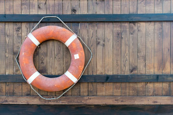 Life buoy hanging on wooden wall for emergency response when people sinking to water almost place near pool and beach