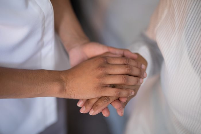 Mid section of nurse comforting patient