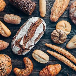 Delicious freshly baked bread on wooden background