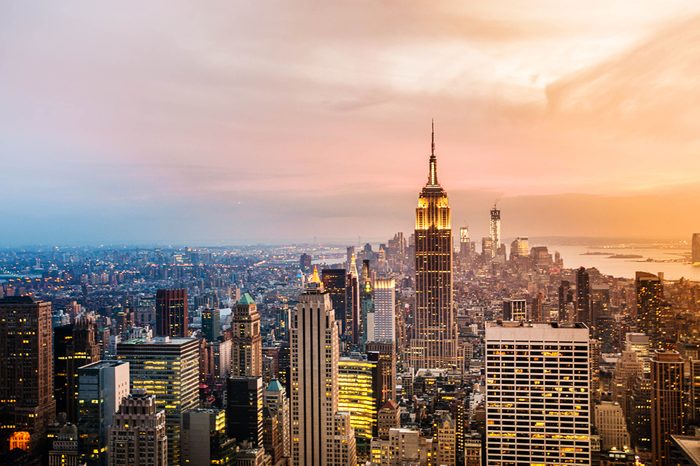 New York City skyline with urban skyscrapers at sunset. 