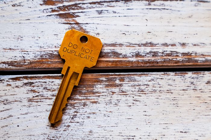 A single key on rustic wooden keyboard with do not duplicate written on it. 