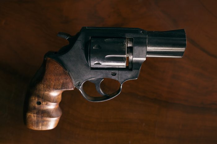 Revolver handgun over wooden background.