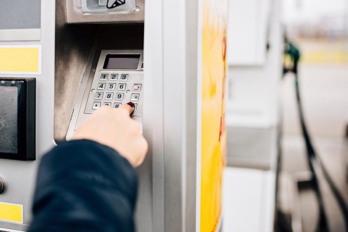 Woman paying with credit card for fuel on self service petrol station