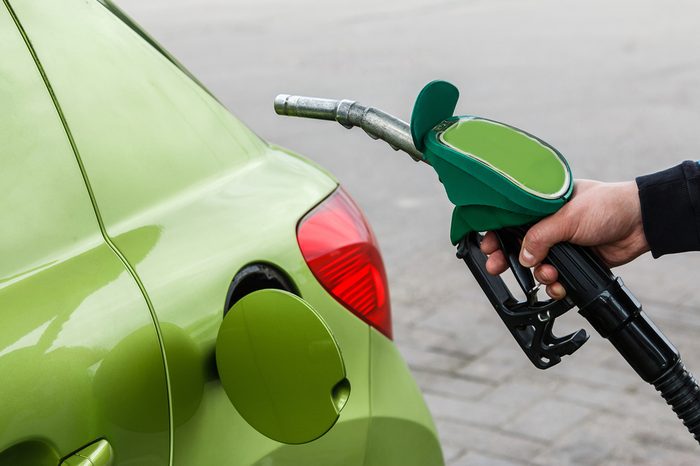 Man fills up his car with a gasoline at gas station