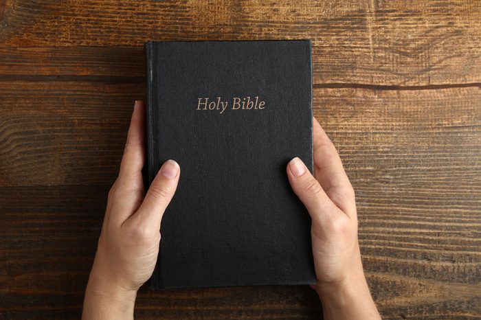 Women's hands holding the Bible. Top view.The concept of religion.