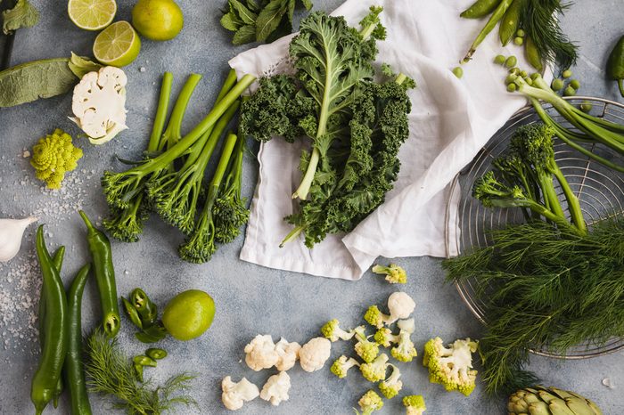 Assorted green vegetables kale leaves tenderstem broccoli peppers cauliflowers pea dill onion asparagus spring vegetables overhead