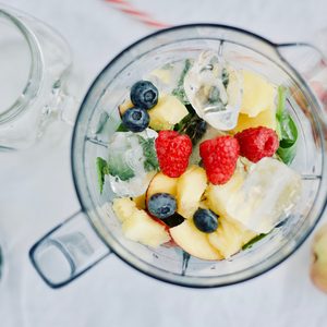 flat-lay of a blender and fresh seasonal berries and fruits over white background, cooking preparing smoothies, detox, healthy clean eating 