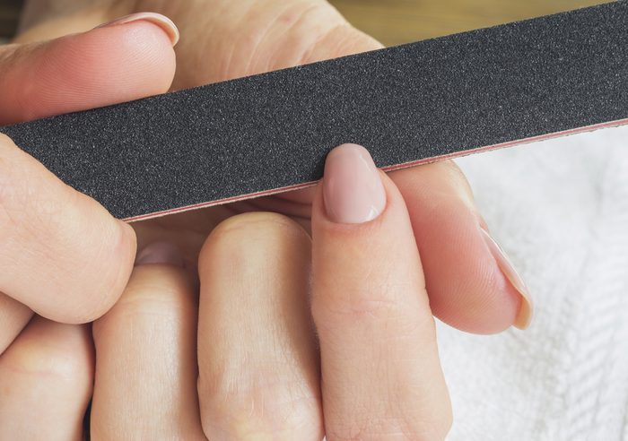 Female hands manicure with nail file.