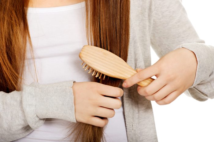 Teen woman brushing her hair.