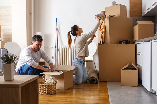 Young couple unpacking cardboard boxes at new home.Moving house.Real estate.