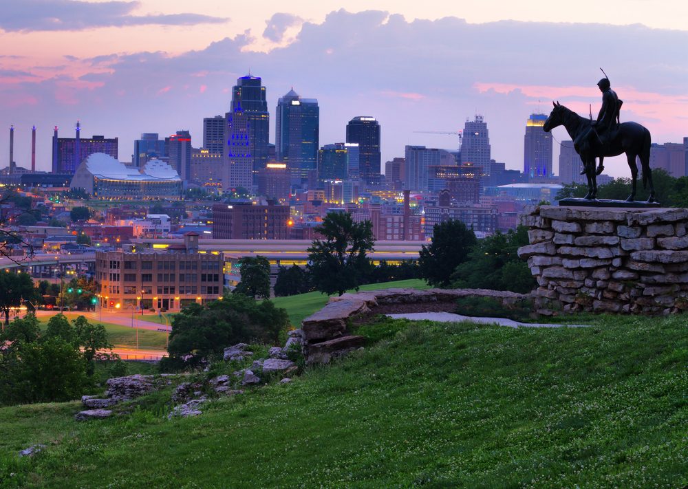 View of Kansas City, Missouri skyline at dawn during golden light from the Kansas City Scout Memorial with all registered trademarks removed.