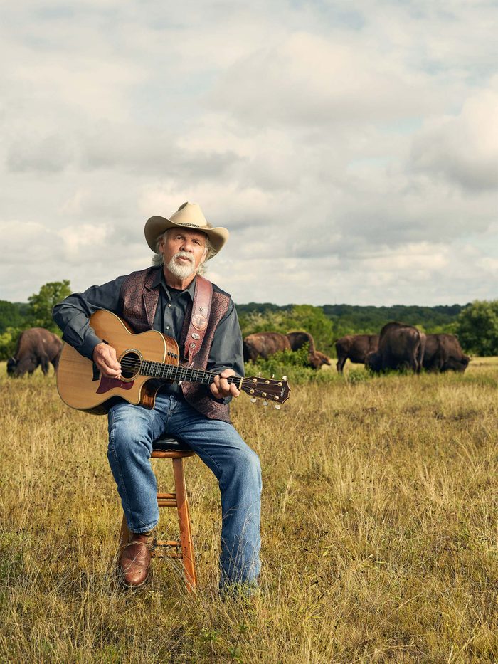 Freddie Fuller playing guitar in field