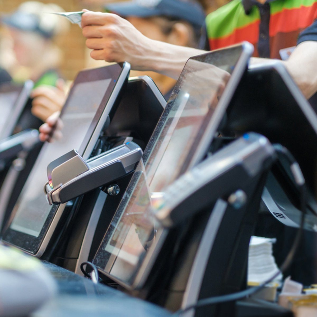 Row of order desks with computer screen and card payment terminal in fast food restaurant