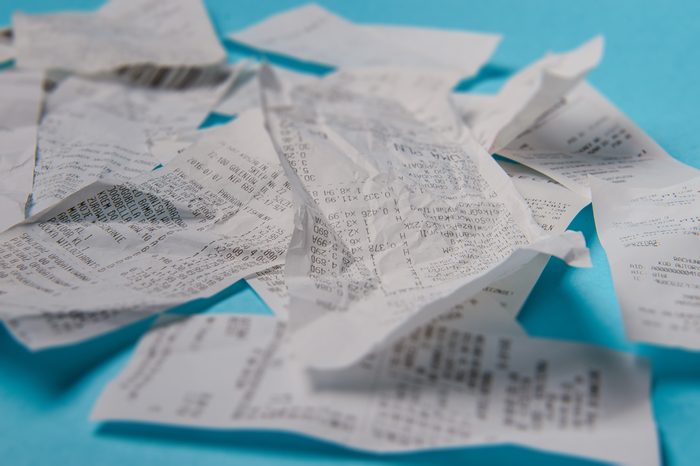 Pile of shopping receipts on a blue background