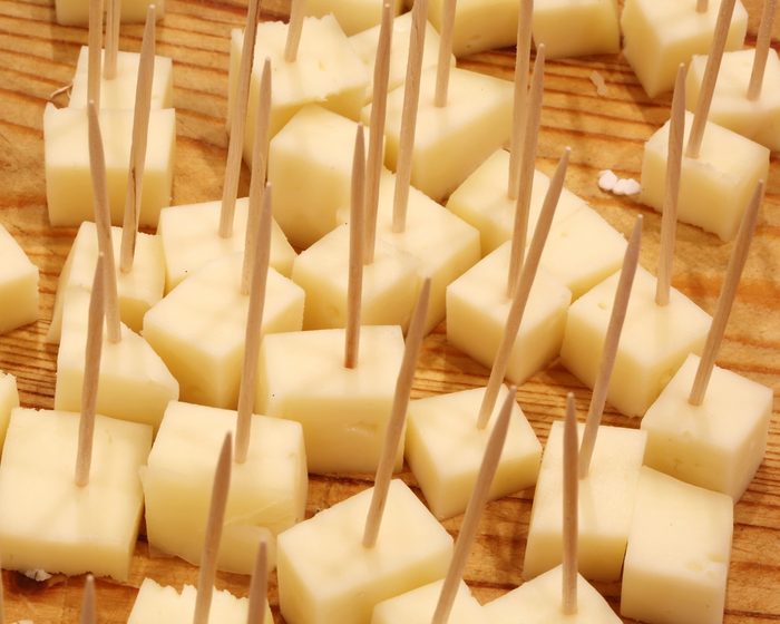 fresh cheese tastings with toothpicks in the cheese shop over the cutting board