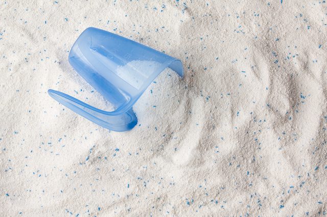 Laundry detergent powder for washing machine and plastic scoop for dosage.