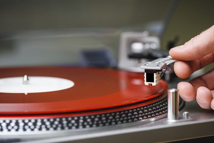 a person placing the needle on a record.