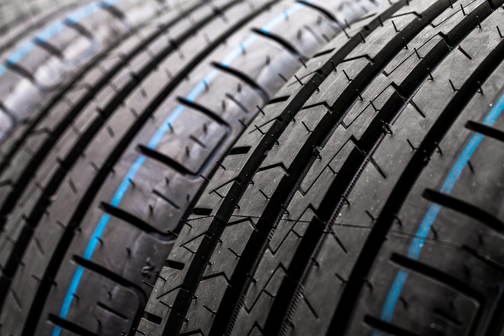Stack of brand new high performance car tires on clean high-key white studio background
