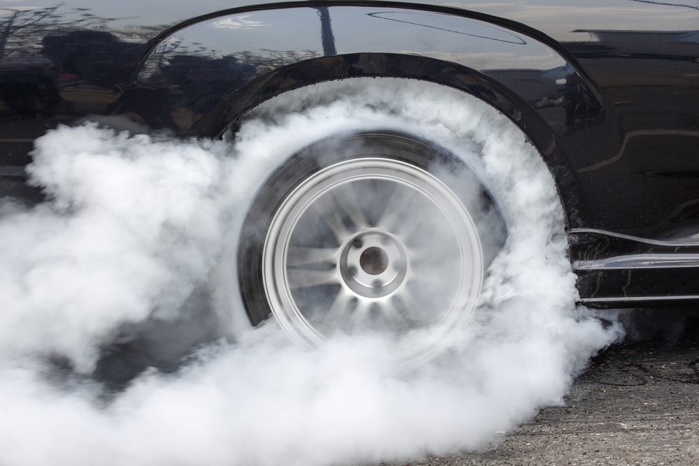 Drag racing car burns rubber off its tires in preparation for the race