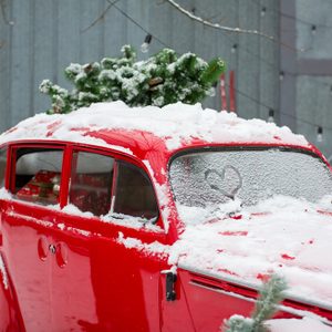 red retro car with a Christmas tree on top and presents