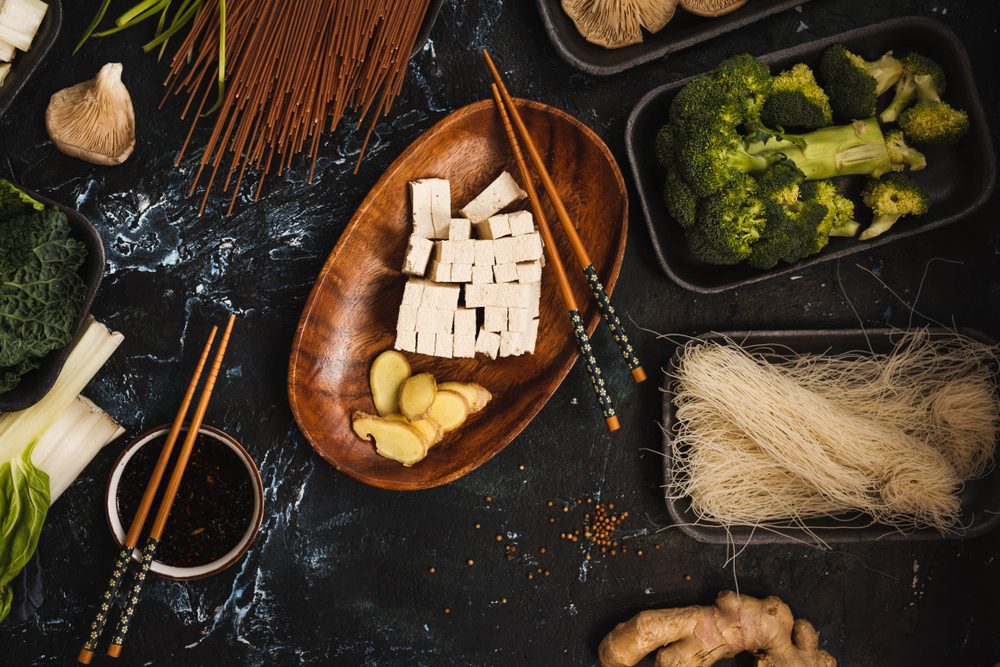 Ingredients for asian ramen soup. Noodles, spring onion, tofu cheese, mushrooms, chicken breast , bok choy cabbage green leafy flat lay 