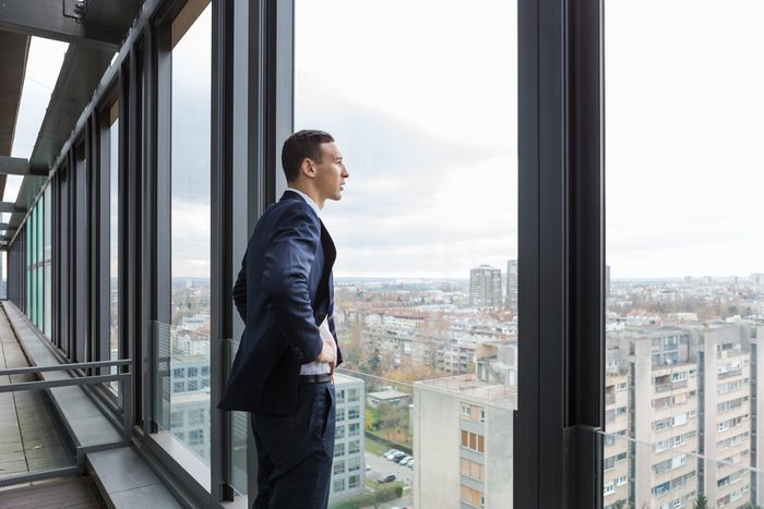 Business man looking out through the office balcony.