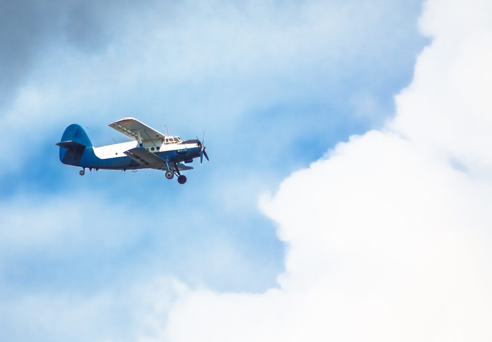 Biplane in blue Sky over clouds