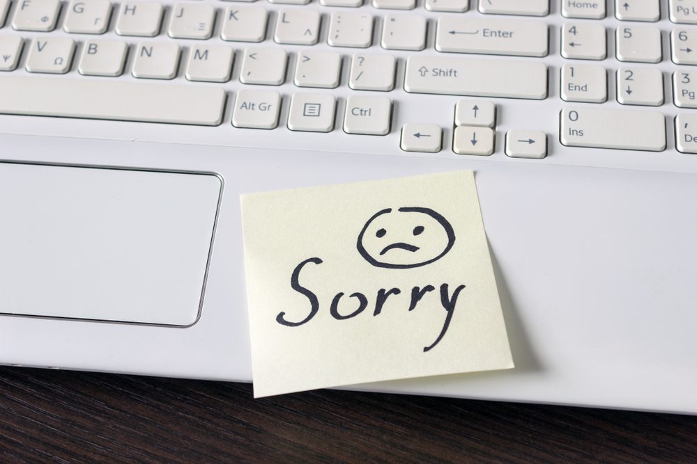 Handwritten note is on the keyboard. - Sorry. Sad smiley face drawn in black.