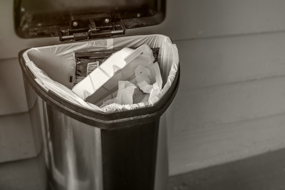 Trash concept with waste bin open and full of garbage. Gross and smelly, black and white and sepia toned HDR image with copy space.